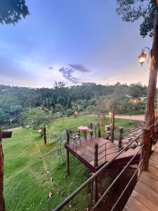 une terrasse en bois avec vue sur un champ dans l'établissement MeGarden Daknong, à Gia Nghĩa