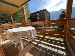 a wooden deck with a table and chairs on it at Appartement Peisey-Nancroix-Plan Peisey, 1 pièce, 4 personnes - FR-1-757-79 in Peisey-Nancroix