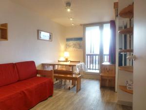 sala de estar con sofá rojo y mesa en Appartement Peisey-Vallandry, 2 pièces, 5 personnes - FR-1-757-80, en Landry