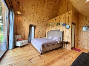 - une chambre avec un lit et un mur en bois dans l'établissement MeGarden Daknong, à Gia Nghĩa