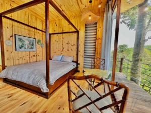 - une chambre avec un lit dans une cabane en bois dans l'établissement MeGarden Daknong, à Gia Nghĩa