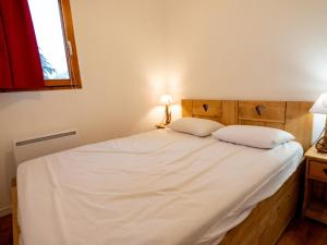 een slaapkamer met een groot wit bed met 2 kussens bij Appartement Valfréjus, 3 pièces, 7 personnes - FR-1-468-118 in Modane