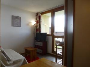 een kamer met een bed, een televisie en een tafel bij Appartement Peisey-Vallandry, 1 pièce, 4 personnes - FR-1-757-68 in Landry