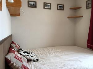 a bed in a room with some pictures on the wall at Appartement Peisey-Vallandry, 2 pièces, 5 personnes - FR-1-757-86 in Landry