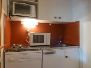 y cocina con fogones, microondas y fregadero. en Appartement Peisey-Vallandry, 1 pièce, 4 personnes - FR-1-757-88, en Landry