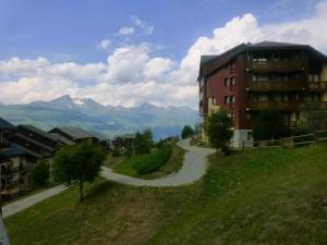 a building on a hill next to a road at Appartement Peisey-Vallandry, 1 pièce, 4 personnes - FR-1-757-88 in Landry