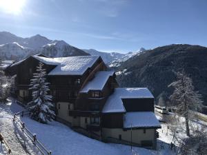 a building covered in snow with mountains in the background at Appartement Peisey-Vallandry, 1 pièce, 4 personnes - FR-1-757-88 in Landry