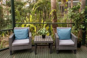 2 sillas y una mesa en una terraza en Lake Russell Retreat, en Emerald Beach