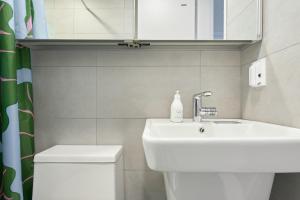 Un baño con lavabo, inodoro y espejo. en La Loge, en Seúl 43 fotos más