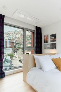 Un dormitorio con una cama y una ventana grande. en La Loge, en Seúl