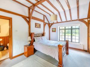 1 dormitorio con cama y ventana grande en Gardeners Cottage, en Kelvedon Hatch