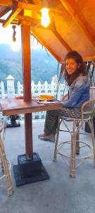 a woman sitting in a chair at a table at Ella Nature Rock in Ella