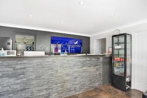 a bar in a room with a brick wall at Lake Macquarie Motor Inn in Belmont