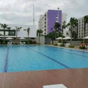 a large blue swimming pool in a city at Bolang Apartel at Aeropolis Apartment in Teko