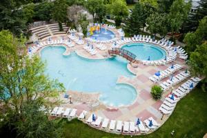 a pool with several tables and chairs in it at Hotel Laguna Garden in Albena