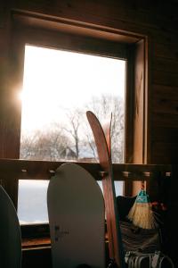 a group of snowboards sitting in front of a window at Alpenglow Lodges Ginkei in Niseko