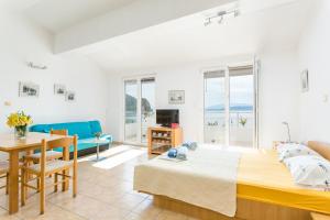 a bedroom with a bed and a table and a couch at Apartments by the sea Zivogosce - Porat, Makarska - 20207 in Igrane