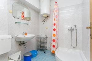 a bathroom with a toilet and a sink and a shower at Apartments by the sea Zivogosce - Porat, Makarska - 20207 in Igrane