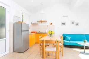 a kitchen and dining room with a refrigerator and a table at Apartments by the sea Zivogosce - Porat, Makarska - 20207 in Igrane