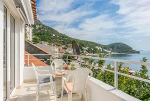 a balcony with a table and chairs and a view of the water at Apartments by the sea Zivogosce - Porat, Makarska - 20207 in Igrane