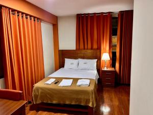 HOTEL LOS ANDES SUITE في تروخيو: غرفة نوم عليها سرير وفوط