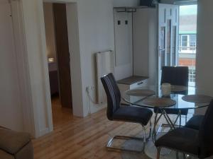 uma sala de jantar com uma mesa de vidro e cadeiras em Apartments Lug 2 new and comfortable with pool em Privlaka