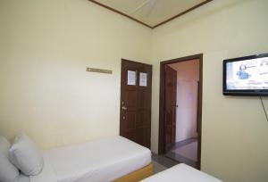 a room with two beds and a flat screen tv at Anggerik Lodging in George Town