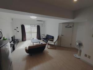 広い60㎡　2LDK　前橋市の中心街にあるマンションの1室 في مايه-باشي: غرفة معيشة مع أريكة وكرسي