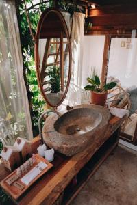 ein Waschbecken mit einem Spiegel auf einer Holztheke in der Unterkunft บ้านนาก๋างโต้ง Baan Na Kang Tong in Ban Kot