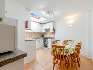 a kitchen with a table and chairs and a refrigerator at Primrose Cottage- Uk45597 in Verwick