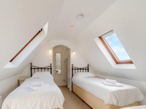 two beds in a attic bedroom with a window at Primrose Cottage- Uk45597 in Verwick