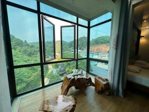 um quarto com uma mesa em frente a uma grande janela em khách sạn thúy phương 2 em Hào Gia