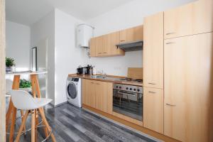 uma cozinha com armários de madeira e uma máquina de lavar roupa em Gemütliches App. Messe / Prater em Viena