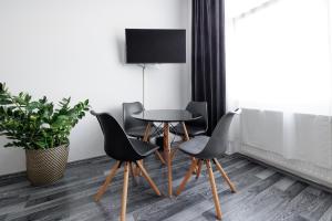 uma mesa e cadeiras num quarto com uma televisão em Gemütliches App. Messe / Prater em Viena