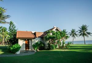 ein Haus am Strand mit Palmen in der Unterkunft Palm Garden Beach Resort & Spa in Hoi An