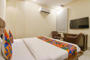 a hotel room with a bed and a flat screen tv at FabHotel Prism Grand in Zirakpur