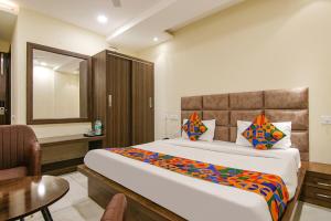 um quarto de hotel com uma cama grande e uma secretária em FabHotel Prism Grand em Zirakpur