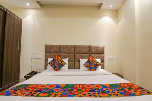 a bedroom with a bed with a colorful blanket on it at FabHotel Prism Grand in Zirakpur