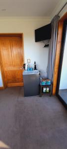 een kamer met een wastafel en een houten deur bij Hill Top Retreat in Lower Dashwood
