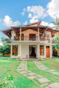 une maison avec un balcon et une cour dans l'établissement SaDev Lake Villa Bandaragama, à Bandaragama
