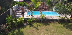 a group of people standing around a swimming pool at Villa Jungle Paradise in Unawatuna