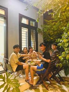een groep mensen die rond een tafel zitten bij Laoxao Homestay in Hội An