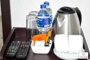 a table with a coffee maker and a thermos and water bottles at PEREGRINE Villa in Polonnaruwa
