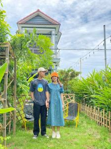 een man en een vrouw die voor een huis staan bij Laoxao Homestay in Hội An +42 foto's