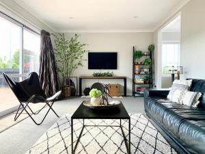 un soggiorno con divano e TV di M&K Home with central heating, 4 bedrooms, by Chartwell Shopping Centre a Hamilton