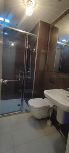 een badkamer met een douche, een toilet en een wastafel bij Aveline Suites Modern Amenity View ACQUA Private Residences near Rockwell Makati in Manilla