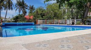 a swimming pool with blue water in front of a fence at Malapascua Beach and Dive Resort in Logon