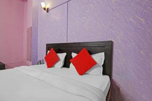 a bedroom with a bed with red pillows on it at Super OYO Flagship Hotel Glorious Stayz in Noida