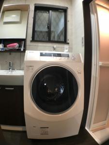 a washing machine in a kitchen next to a sink at ゲストハウス　三宮えびすや in Kobe