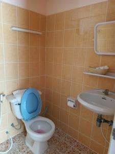 baño con aseo con tapa azul y lavamanos en Patong Rose Guest House, en Patong Beach